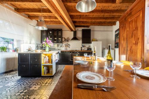 - une cuisine avec une table en bois et des verres à vin dans l'établissement La Maison Perchée, à Thiers