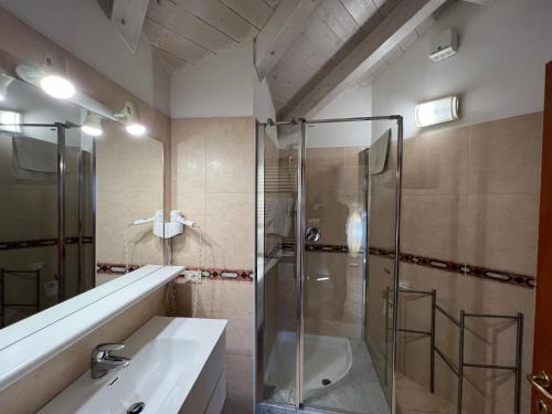 un baño con ducha y lavabo en Mansarda Baia Azzurra 8, en Nago-Torbole