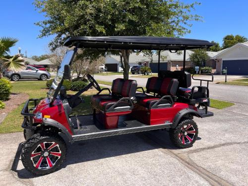 un carro de golf rojo estacionado en una calle en Exclusive Beach Villa with Private HeatedPool, HotTub, Golf Cart & Bikes, en Destin