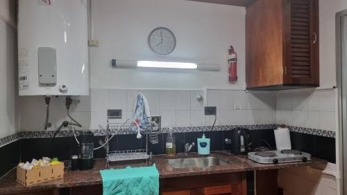 a kitchen with a sink and a clock on the wall at departamento temporario de 1 a 4 personas in Posadas