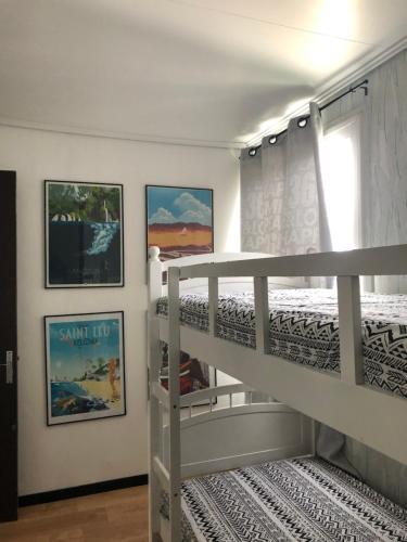 a bedroom with two bunk beds and a window at 2 cap beach in Saint-Pierre