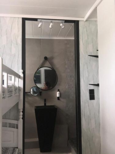 a bathroom with a mirror on the wall at 2 cap beach in Saint-Pierre