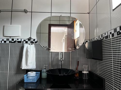 uma casa de banho com um lavatório preto e um espelho em Apartamento INTEIRO próximo ao Aeroporto em Marabá