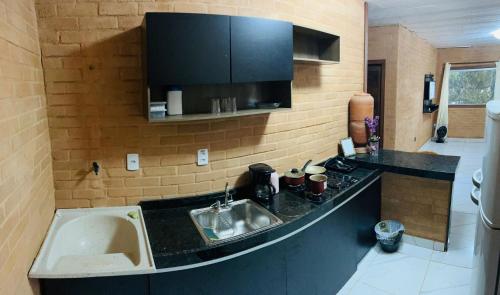 uma cozinha com um lavatório e uma bancada em GV Apartamentos- 2qt-ar cond- area central com vista espetacular em Governador Valadares