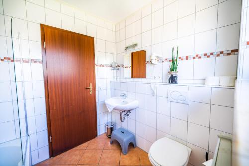 a bathroom with a toilet and a sink at Schwarzfelder Hof in Leipheim