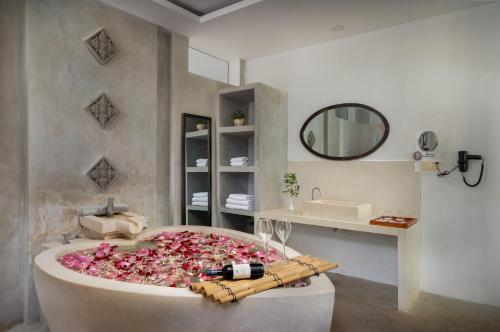 a bathroom with a bath tub filled with pink flowers at Bopha Wat Bo Residence in Siem Reap