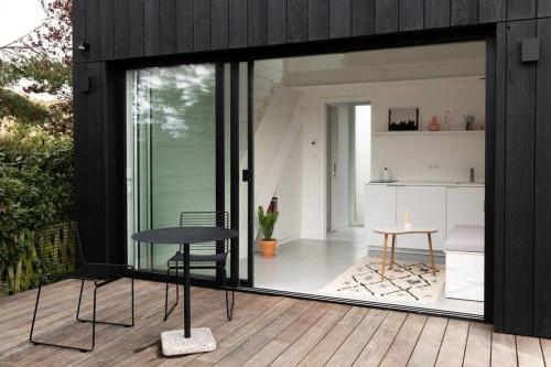 a room with sliding glass doors and a table on a deck at Tiny House d'exception au bord de mer in La Bernerie-en-Retz