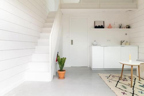 a white room with a table and a potted plant at Tiny House d'exception au bord de mer in La Bernerie-en-Retz