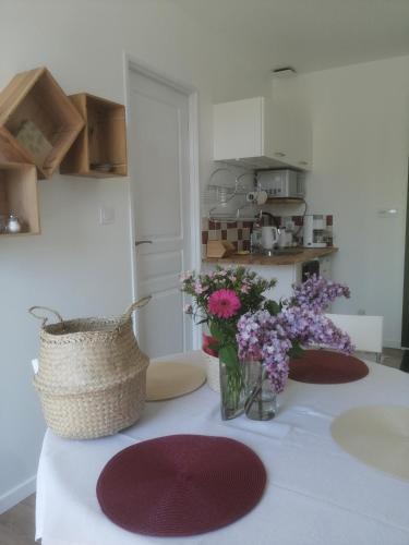 une cuisine avec une table avec un vase de fleurs dessus dans l'établissement Les Bouches Manon, à Pressagny l'Orgueilleux