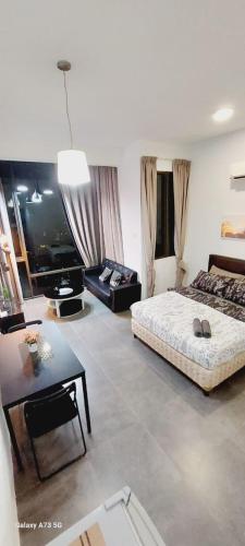 a living room with a bed and a table at Maya empire studio in Kampong Bukit Lanjan