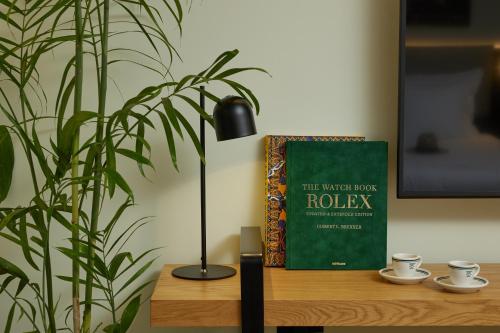 a black lamp sitting on a table next to a book at Rephael House Boutique Hotel in Rishon LeẔiyyon