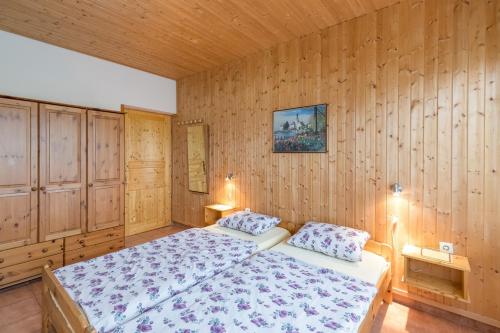 1 Schlafzimmer mit Holzwänden und 1 Bett mit 2 Kissen in der Unterkunft Ines & Hans in Tar