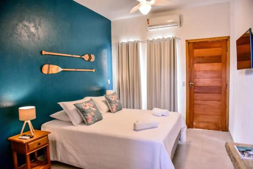 a bedroom with a bed and a blue wall at Villa Samoa - Ilhabela in Ilhabela