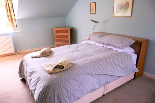 a bedroom with a bed with two towels on it at The Stables in Carsethorn