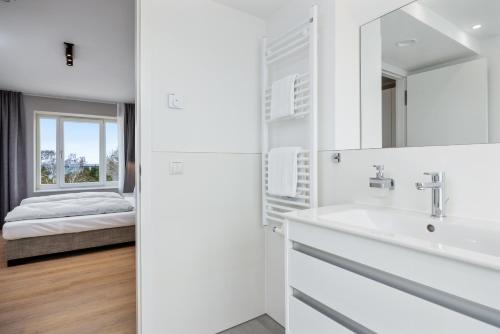 a white bathroom with a sink and a mirror at Strandresidenzen Binz-Prora Strandresidenzen Binz-Prora D5 5 in Binz