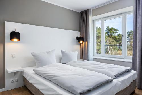 2 camas num quarto com uma janela em Strandresidenzen Strandresidenzen Haus Dänholm 2 3 em Binz