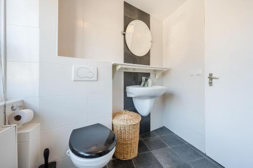 a small bathroom with a toilet and a sink at Cosy & modern 3 bedroom house close to the beach in Katwijk aan Zee