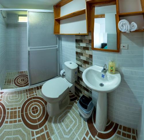 W łazience znajduje się toaleta, umywalka i prysznic. w obiekcie Chalet Íntimo con Jacuzzi interior ! Delpilar w mieście Sogamoso