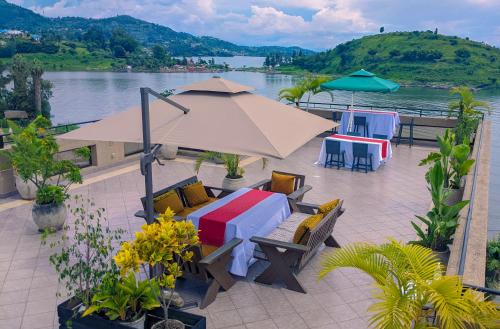 um pátio com uma mesa, cadeiras e um guarda-sol em Kivu Hilltop View Resort em Gisenyi
