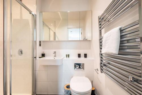 a bathroom with a toilet and a sink and a shower at Saffira - 2 bedroom Flat in Bracknell