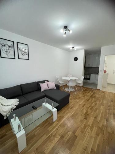 uma sala de estar com um sofá preto e uma mesa em Natalija Stan na dan em Banja Luka