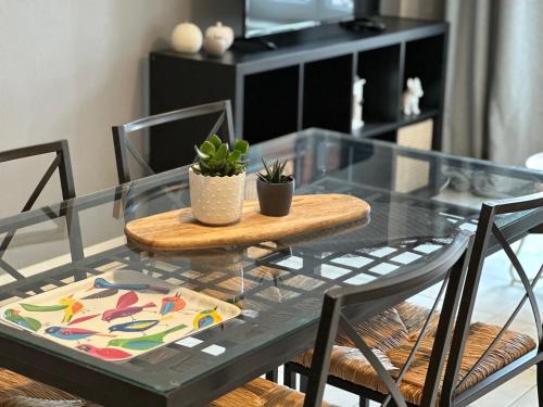 une table en verre avec deux chaises et un plateau de table en verre dans l'établissement appartement duplex proche de la gare et du centre ville, à Saint-Omer