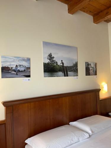 a bedroom with a bed and two pictures on the wall at Hotel Villa Venus Resort & SPA in Atena Lucana