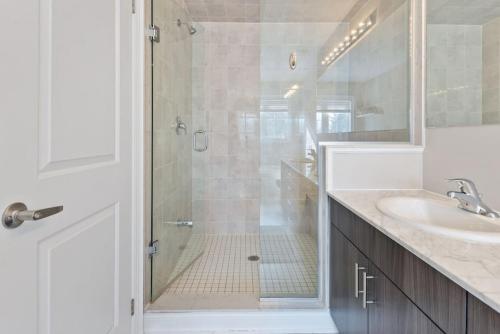 ein weißes Bad mit einer Dusche und einem Waschbecken in der Unterkunft Mountain View Townhouse Fresh and Bright at Blue in Collingwood