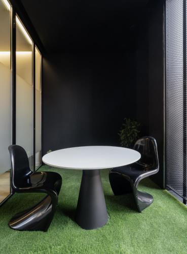 a meeting room with a white table and two black chairs at Cosy Loft's Valencia in Catarroja