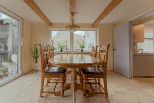 uma sala de jantar com uma mesa de madeira e cadeiras em Cozy Cottage / 3BR / Hiking / Nature em Við Gjógv