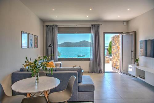 a living room with a couch and a table at Blue Cove Zen in Elounda