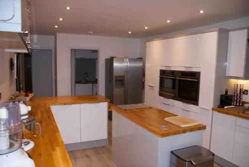 a kitchen with white cabinets and a stainless steel refrigerator at Luxury detached house - Village 