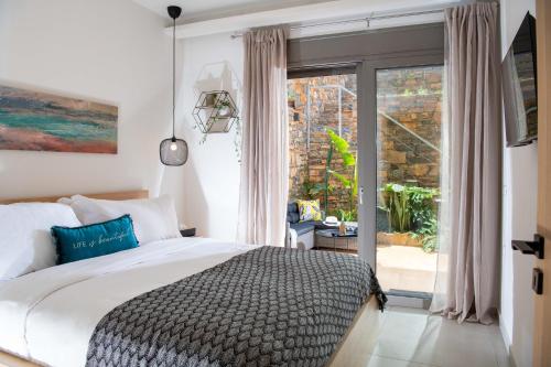 a bedroom with a bed and a sliding glass door at Blue Cove Zen in Elounda