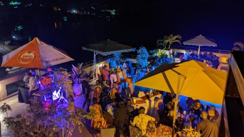 a group of people standing under umbrellas at night at Kivu Hilltop View Resort in Gisenyi