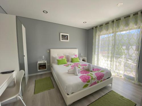 a bedroom with a bed and a desk and a window at Cantinho Verde T1 in Geres