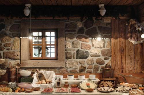 een keuken met een tafel vol eten en een stenen muur bij Hotel Los Andes in Castello di Fiemme
