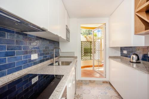 cocina con fregadero y azulejos azules en Modern apartment with terrace, en Marbella