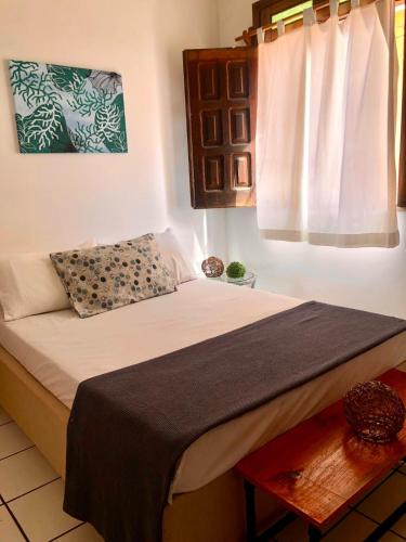 a bedroom with a bed in a room with a window at Pousada Caracola in Morro de São Paulo