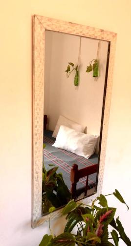a mirror on a wall with a bed in a room at Pousada Caracola in Morro de São Paulo