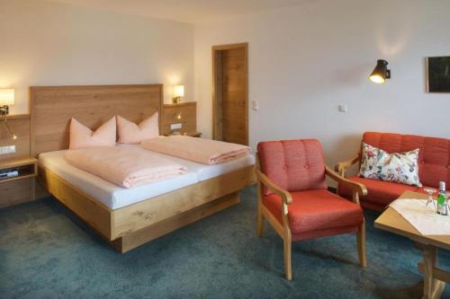 1 dormitorio con cama, escritorio y silla en Landhaus Seeblick, en Füssen