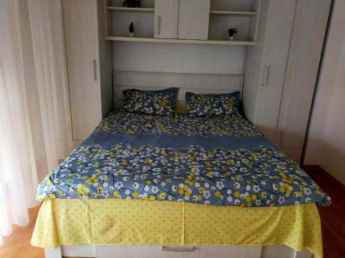Un dormitorio con una cama con una colcha azul y amarilla. en Victoria Residence, en Bucarest