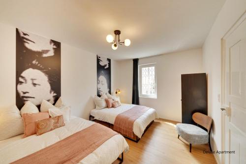 a bedroom with two beds and a chair at Stuttgart am Wasen Toplage 4Zi 80qm in Stuttgart