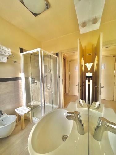 a bathroom with a tub and a sink and a shower at Hotel Adria in Milano Marittima