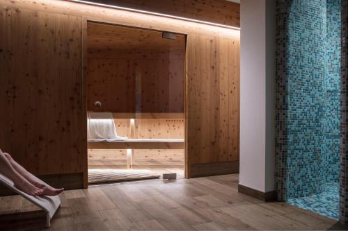 um quarto com um chuveiro e uma porta de vidro em Hotel Los Andes em Castello di Fiemme