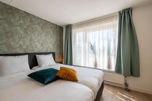 a bedroom with a bed with a large window at Maxime 296 - Kustpark Village Scaldia in Hoofdplaat