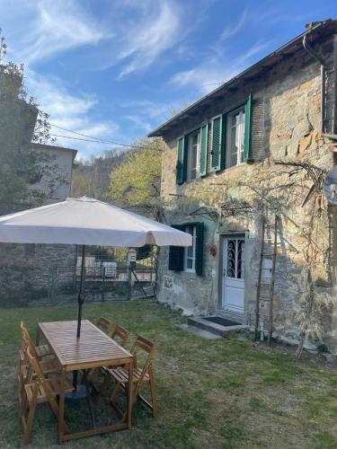 a table with an umbrella in front of a building at La Casina del Bassotto in Bagni di Lucca
