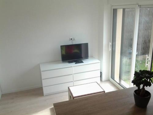 Televízia a/alebo spoločenská miestnosť v ubytovaní Appartement avec Jardin