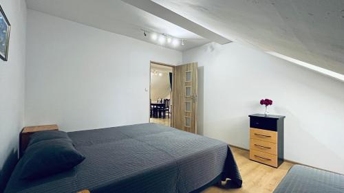 een slaapkamer met een bed en een ladekast erin bij Apartament Pod Kasztanami - BIAŁY in Ińsko
