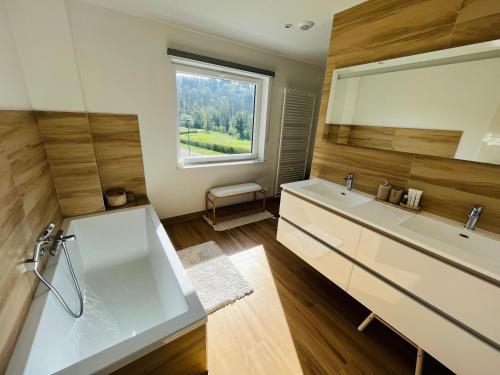 uma casa de banho com 2 lavatórios e uma grande janela em Maison familiale à Dinant em Dinant