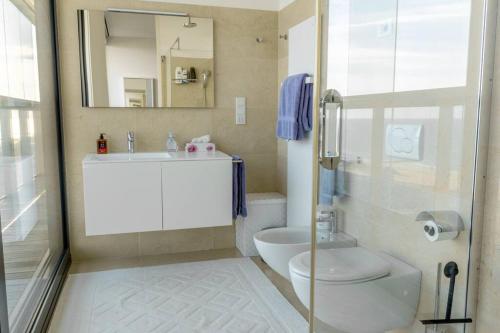 La salle de bains est pourvue d'un lavabo, de toilettes et d'un miroir. dans l'établissement Merville 15 piano, à Lido di Jesolo